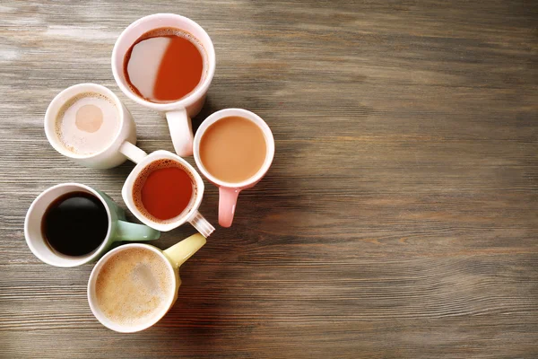 Muchas tazas de café sobre fondo de madera — Foto de Stock