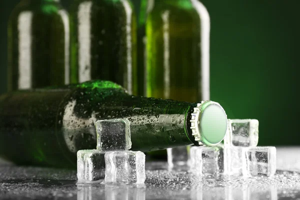 Bouteilles de bière en verre avec glaçons sur fond sombre — Photo