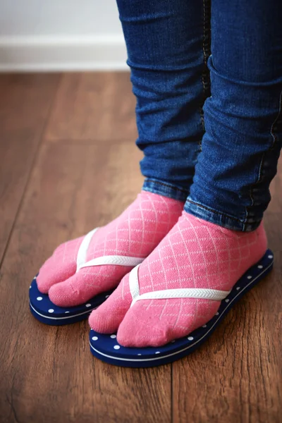 Pés femininos em meias com chinelos rosa — Fotografia de Stock