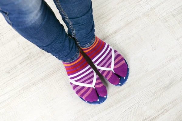 Pies femeninos en calcetines con chanclas rosas — Foto de Stock