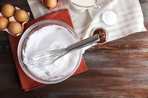 Blancs d'œufs fouettés et autres ingrédients pour crème sur table en bois, vue de dessus — Photo