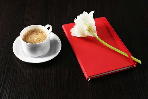 Taza de café con cuaderno y flor fresca sobre fondo de mesa de madera —  Fotos de Stock