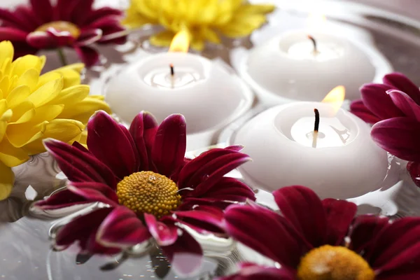 Skål med spa vatten med blommor och ljus — Stockfoto