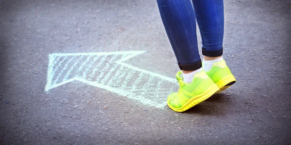 Female feet and drawing arrow — Stock Photo, Image