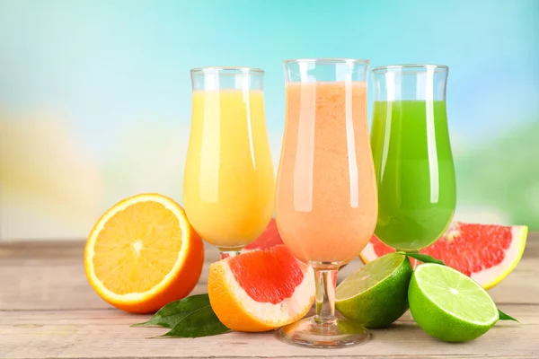 Fresh summer cocktails with fruits on wooden table on bright blurred background — Stock Photo, Image