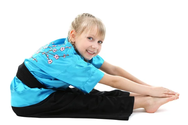 Little girl in kimono doing exercises isolated on white — Stock Photo, Image