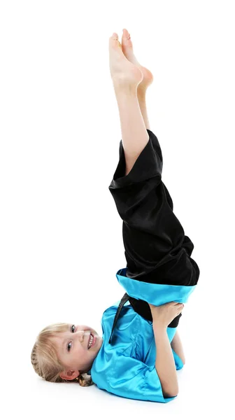 Little girl in kimono doing exercises isolated on white — Stock Photo, Image