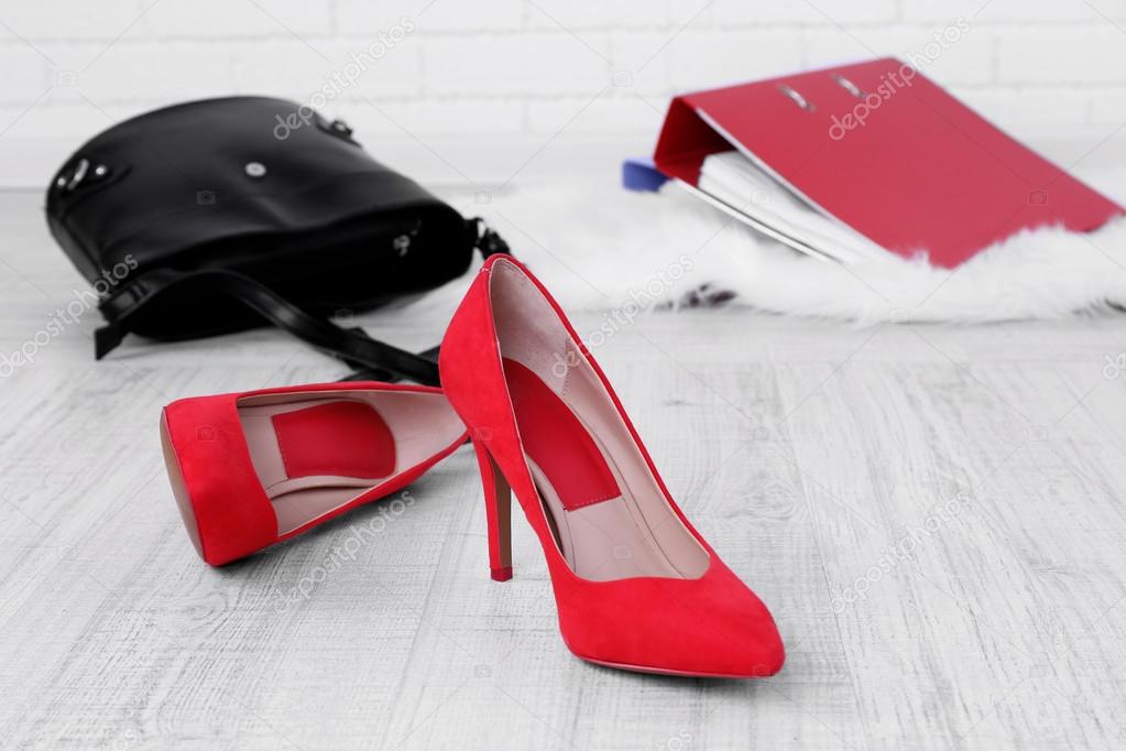 Female shoes and briefcase on floor background