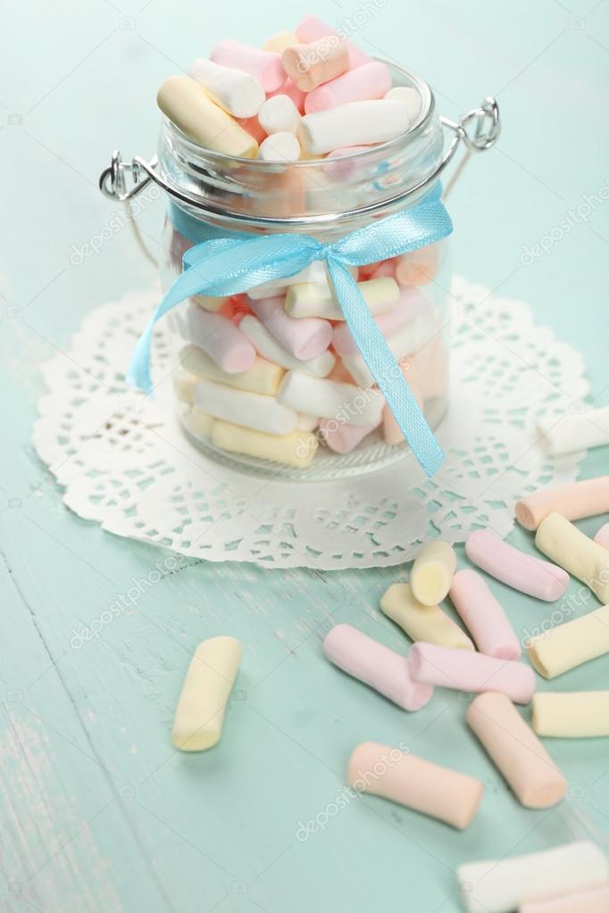 Sweet candies on color wooden table, closeup