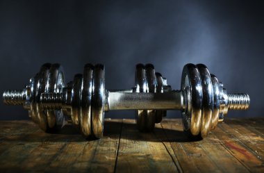 Koyu arka plan üzerinde ahşap tahta üzerinde halter