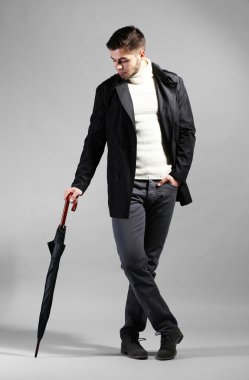 gri arka plan üzerinde şemsiye ile zarif adam