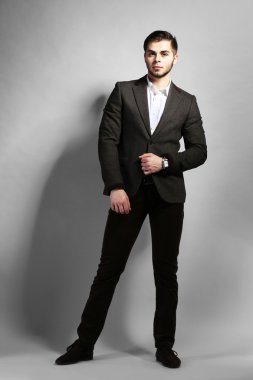 gri arka plan üzerinde takım elbiseli şık adam
