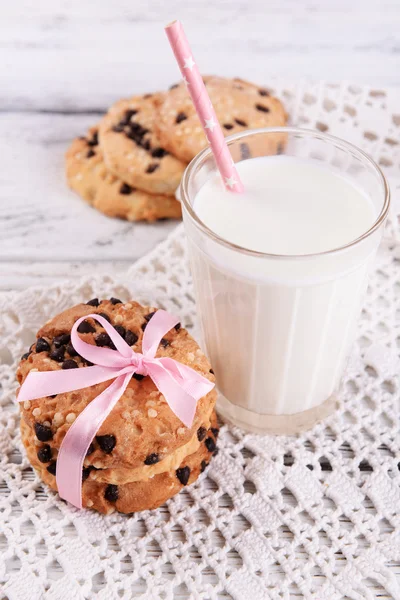 Tasty cookies and glass of milk on color wooden table, on bright background — Stock Photo, Image