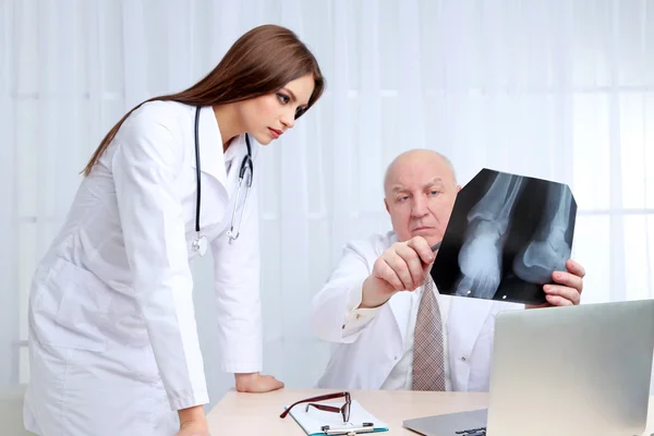 Los médicos que reciben resultados de rayos X en la oficina sobre fondo blanco —  Fotos de Stock