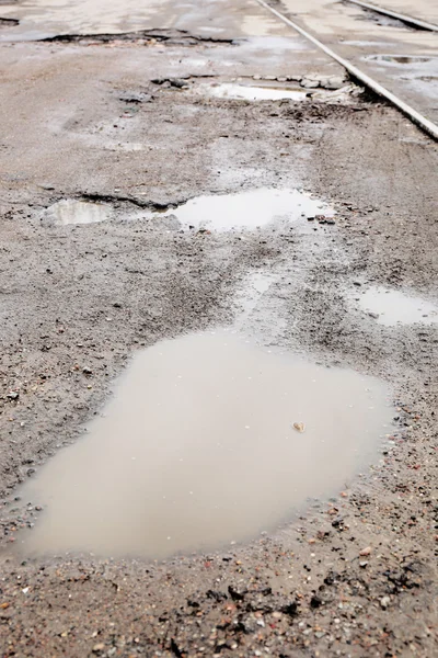 Very bad quality road with potholes and puddles — Stock Photo, Image