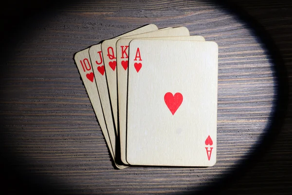 Spielkarten im Licht auf Holztisch, Draufsicht — Stockfoto