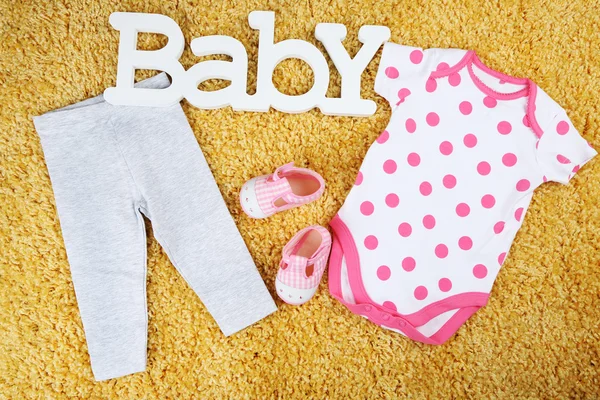 Clothes for baby girl on colorful background — Stock Photo, Image