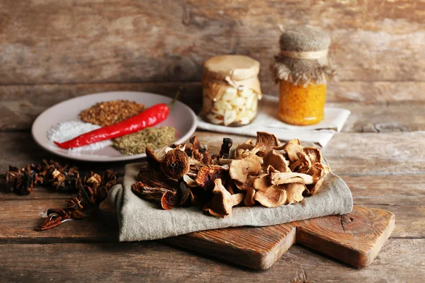 Dried mushrooms with spices on wooden background — Stock Photo, Image