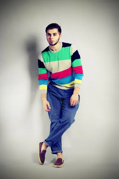 Hombre joven en estilo casual sobre fondo gris — Foto de Stock