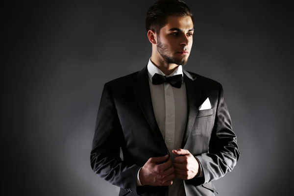 Элегантный мужчина в костюме на тёмном фоне — стоковое фото
