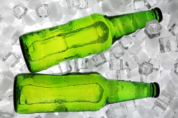 Botellas de vidrio de cerveza sobre fondo de cubos de hielo — Foto de Stock