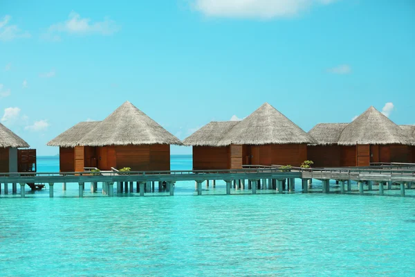 Blauwe oceaanwater en bungalows — Stockfoto