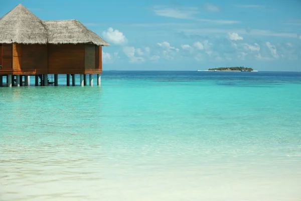 Blauwe oceaanwater en bungalows — Stockfoto