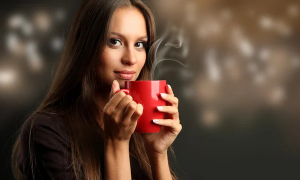 Όμορφη νεαρή γυναίκα με φλιτζάνι καφέ — Φωτογραφία Αρχείου