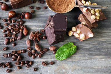 çikolata fındık, otlar ve ahşap masa, closeup üzerinde kahve çekirdekleri ile kümesi