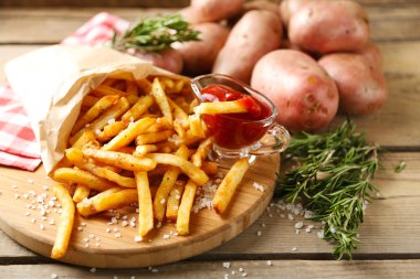 Tahtada patates kızartması, ahşap masa arkasında.