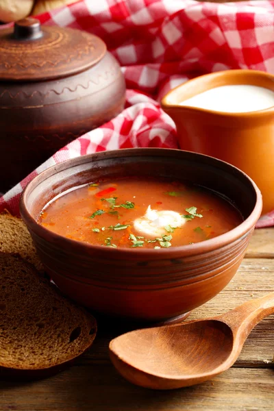 Ukrainian beetroot soup - borscht in bowl and pot, on napkin, on wooden background — Stock Photo, Image