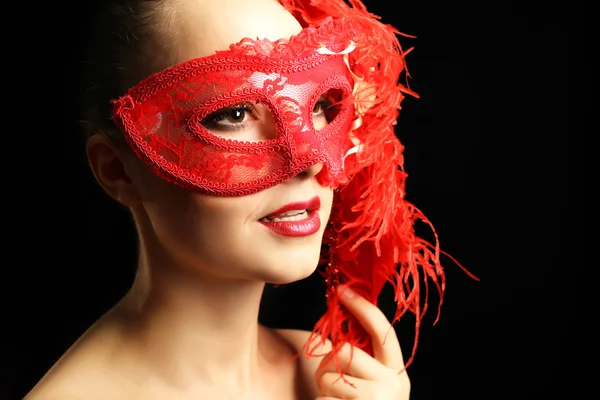 Portrait of beautiful woman with fancy glitter makeup and masquerade mask on dark background — Stock Photo, Image