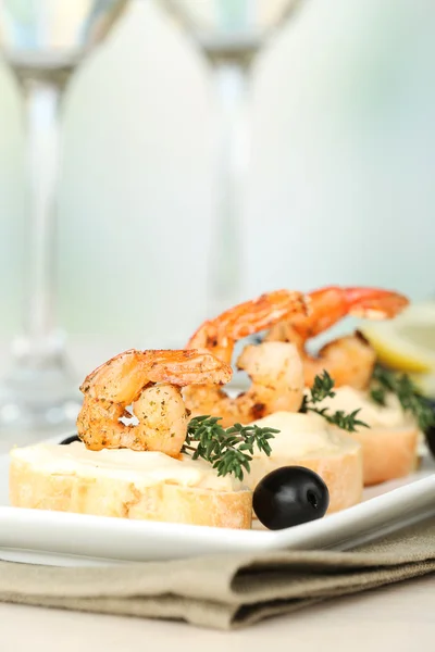 Vorspeise Canape mit Garnelen und Oliven auf dem Tisch auf hellem Hintergrund — Stockfoto