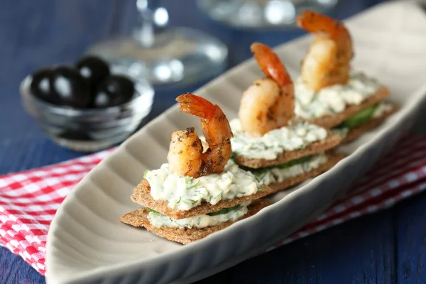Appetizer canape with shrimp and cucumber on plate on table close up — Stock Photo, Image