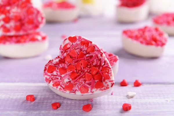 Delicious chocolate candies in heart shape on table close-up — Stock Photo, Image