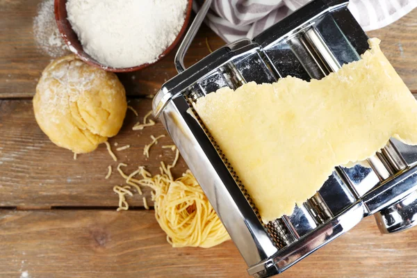 Making vermicelli with pasta machine on wooden background — Stock Photo, Image