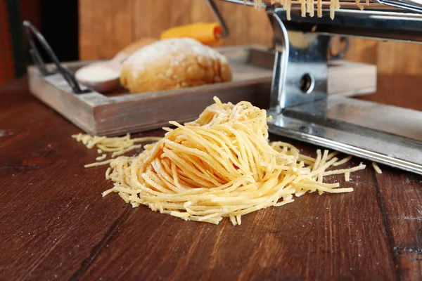 Hacer vermicelli con máquina de pasta sobre fondo de madera —  Fotos de Stock