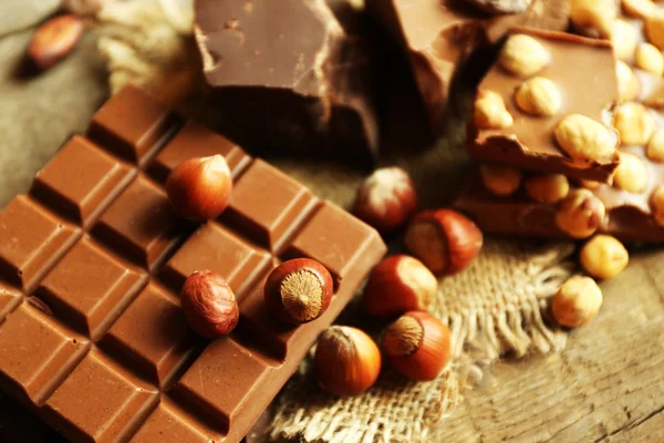 Stilleben med uppsättning av choklad med nötter på träbord, närbild — Stockfoto