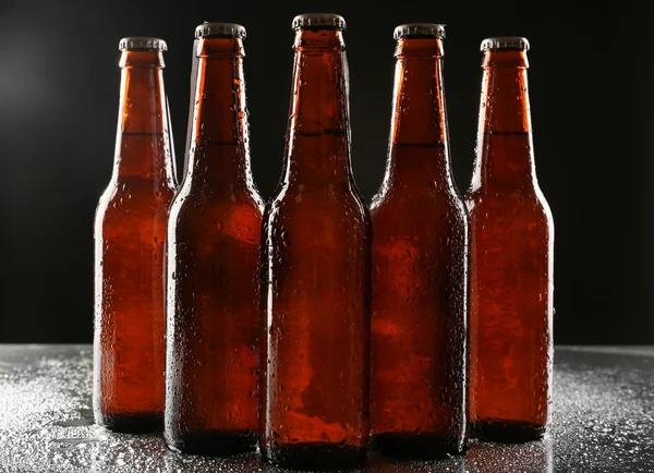 Bottiglie di vetro di birra su sfondo scuro — Foto Stock