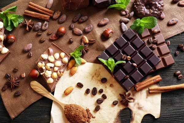 Chocolate with mint, spices and coffee beans on table, closeup — Stock Photo, Image