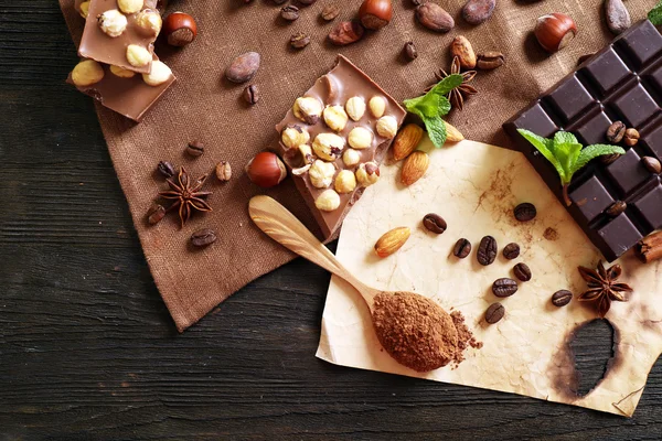 Chocolate com hortelã, especiarias e grãos de café na mesa, close-up — Fotografia de Stock