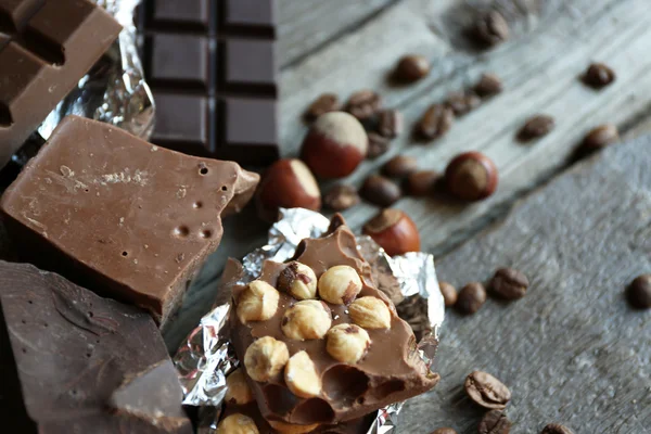 Набор шоколада с орехами на деревянном столе, крупным планом — стоковое фото