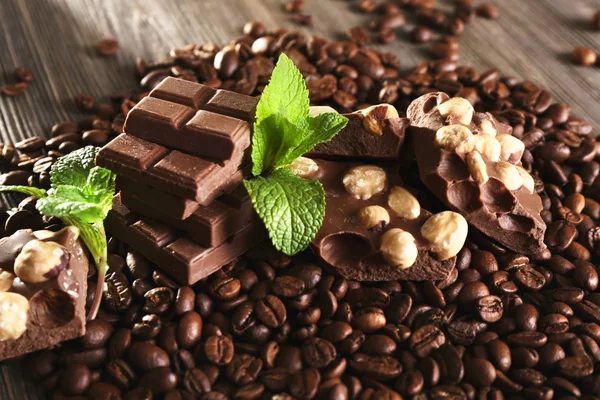 Chocolate with mint and coffee beans on wooden table, closeup — Stock Photo, Image