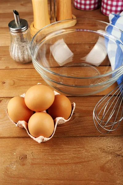 Preparation cream with eggs in glass bowl on wooden background — Stock Photo, Image