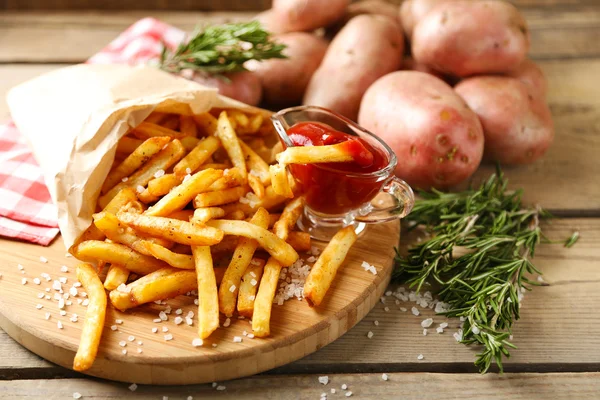 Smaklig pommes frites på skärbräda, på träbord bakgrund — Stockfoto