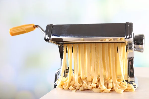 Making noodles with pasta machine on light background — Stock Photo, Image