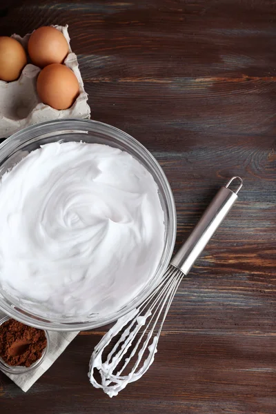 Blancs d'œufs fouettés et autres ingrédients pour crème sur table en bois, vue de dessus — Photo