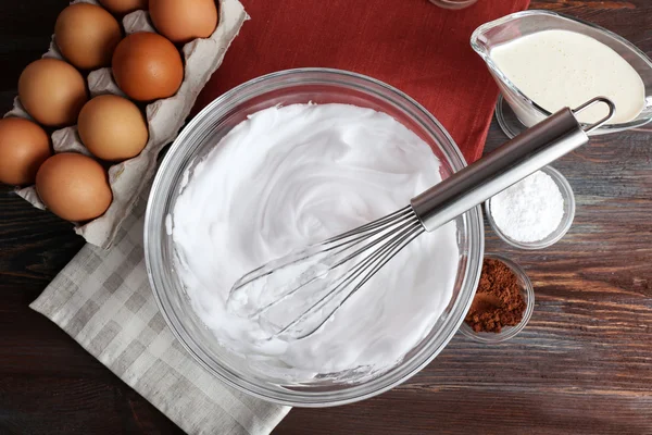 Felvert tojásfehérjét, tejszín esetében a fából készült asztal, felülnézet — Stock Fotó