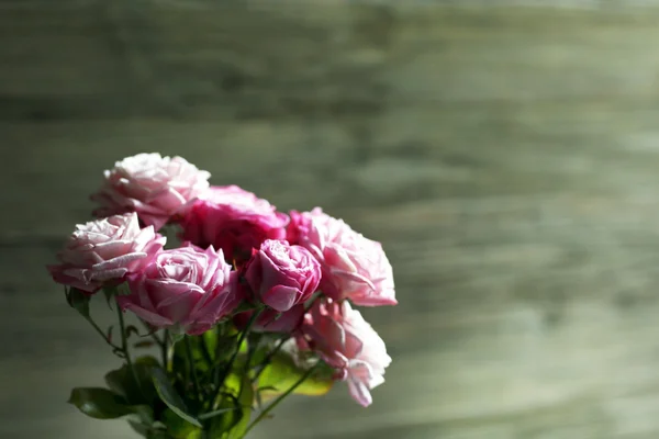 Ramo de hermosas rosas frescas sobre fondo de madera — Foto de Stock