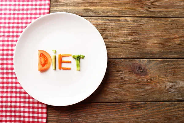 Word DIET lavet af skiver grøntsager i hvid plade med serviet på træbaggrund - Stock-foto
